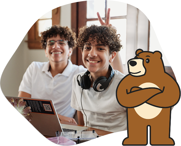 Alumnos de California Virtual Academies trabajando juntos con sus portátiles. En esta imagen también aparece la mascota, un oso, junto a los alumnos.