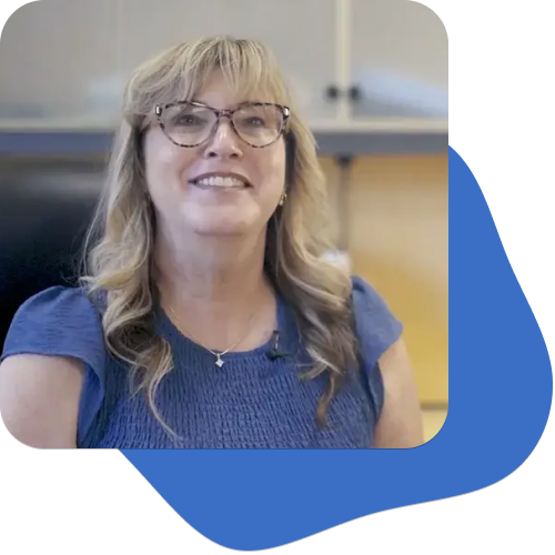 April Warrent, directora del colegio, con una camisa azul claro y sus gafas
