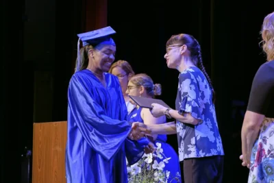 Imagen de una estudiante de posgrado recibiendo su diploma