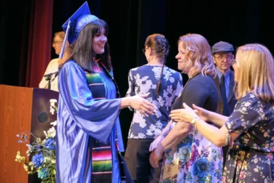 Imagen de un graduado dando la mano a un profesor