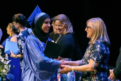 Imagen de una estudiante de posgrado recibiendo su diploma